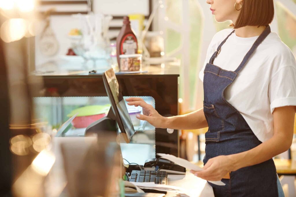 A woman in an apron is working at the counter.