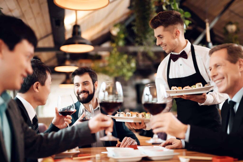 A group of people sitting at a table with food.