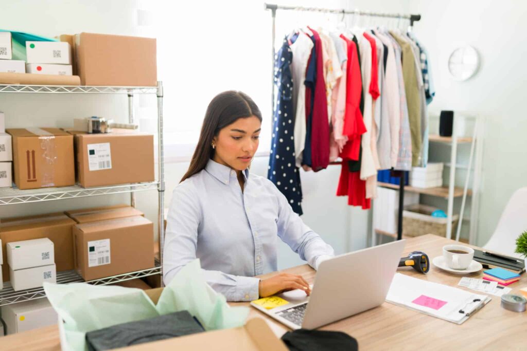 A woman sitting at her desk on top of the laptop.