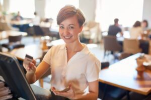 A woman holding a cell phone and smiling.