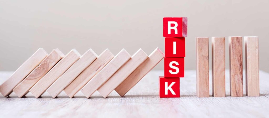 A wooden block with the word risk written on it.