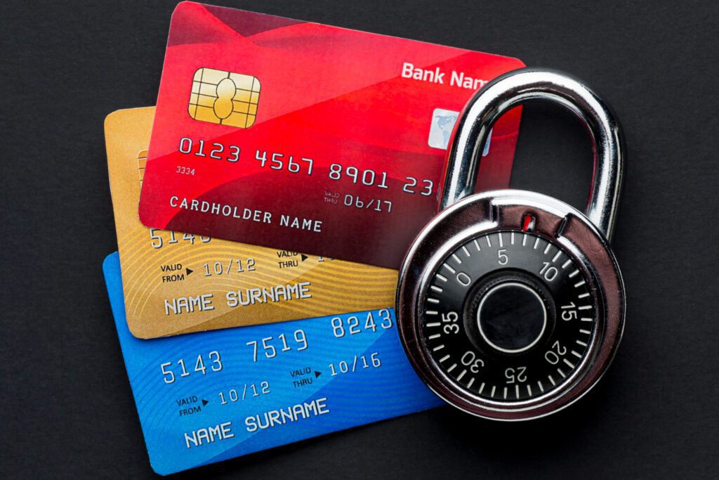 A padlock sitting on top of three credit cards.