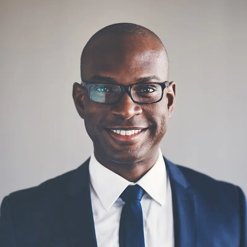 A man in a suit and tie smiling for the camera.