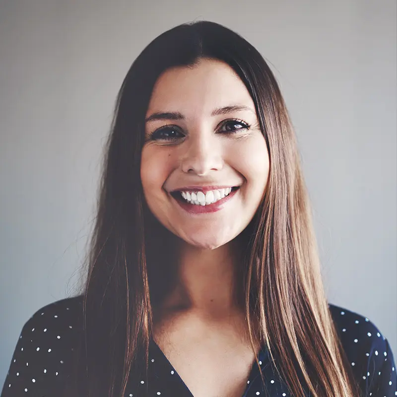 A woman with long hair and a polka dot shirt.