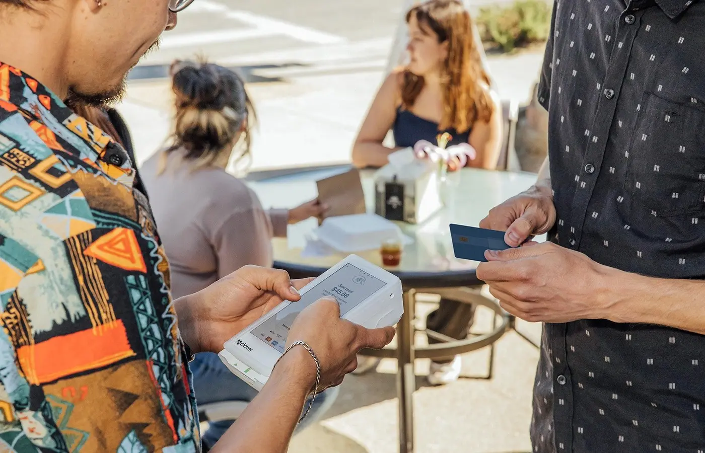 A group of people sitting at tables with phones.