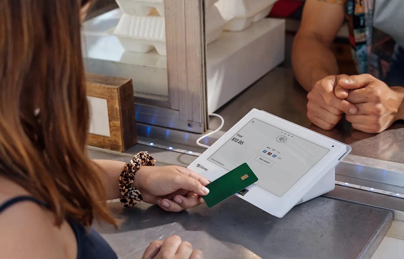 A woman holding a credit card over an ipad.