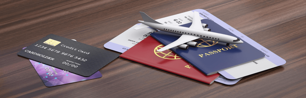 A wooden table with an airplane and passport on it.