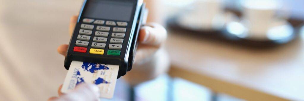 A person holding their credit card and using the phone.